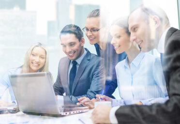update-blog2 Equipo comercial revisando información en una tablet durante una reunión de ventas